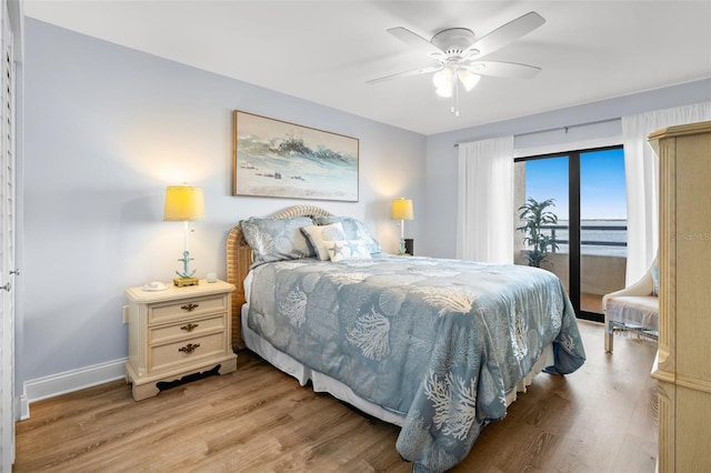 bedroom featuring ceiling fan, a water view, and light hardwood / wood-style floors