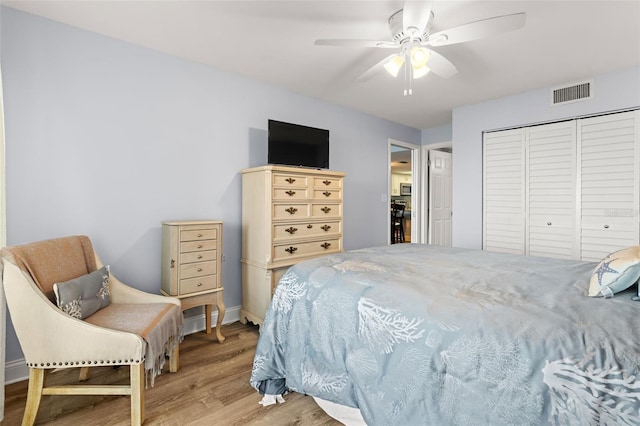 bedroom with light hardwood / wood-style flooring, a closet, and ceiling fan