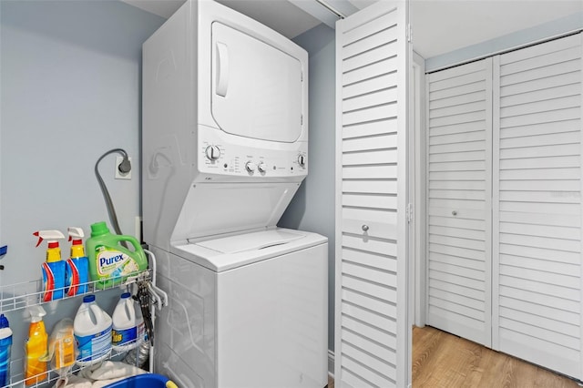 washroom featuring stacked washer and clothes dryer and light wood-type flooring