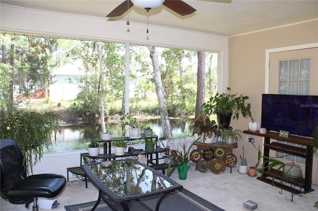 sunroom featuring a water view and ceiling fan