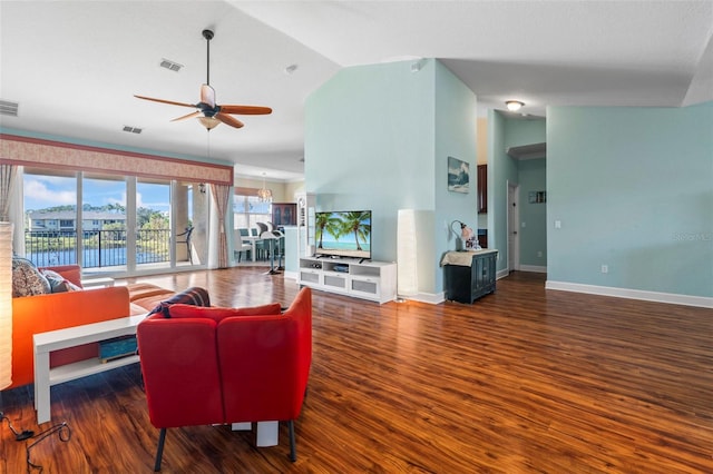 living room featuring dark wood-type flooring, ceiling fan, and vaulted ceiling