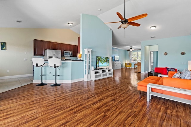 living room with hardwood / wood-style flooring, high vaulted ceiling, and ceiling fan