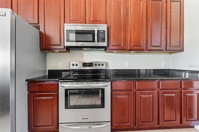 kitchen featuring appliances with stainless steel finishes and dark stone counters