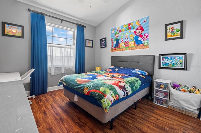 bedroom featuring dark hardwood / wood-style flooring, vaulted ceiling, and ceiling fan