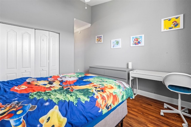 bedroom with dark wood-type flooring and a closet