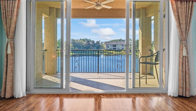 doorway featuring wood-type flooring, a water view, and ceiling fan