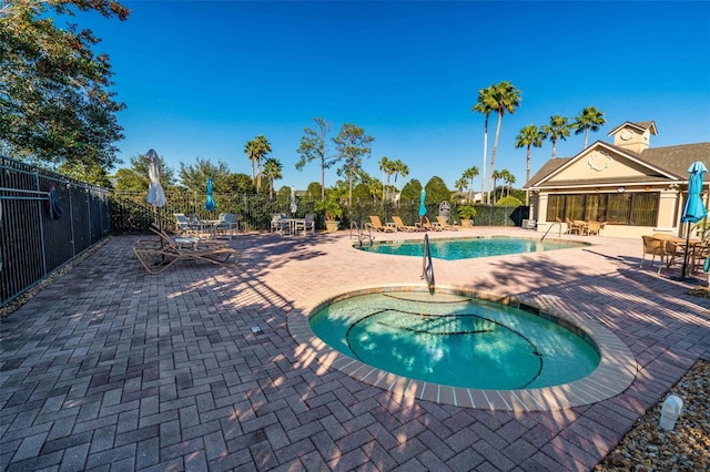 view of swimming pool with a hot tub and a patio area