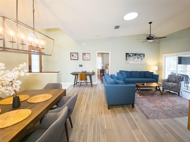 living room featuring ceiling fan, light hardwood / wood-style floors, and vaulted ceiling