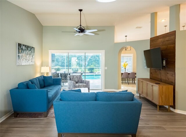 living room with hardwood / wood-style floors, ceiling fan, and lofted ceiling