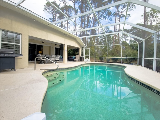 view of swimming pool featuring a lanai and a patio