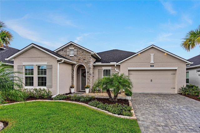 597 Mosaic Blvd, Daytona Beach, FL 32124 - traditional-style house with decorative driveway, a front yard, a garage, stucco siding, and stone siding