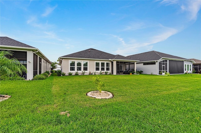 back of house with a lawn and a sunroom