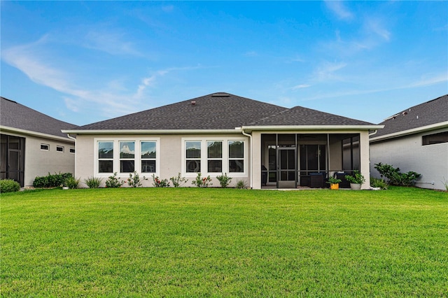 rear view of property featuring a sunroom and a yard