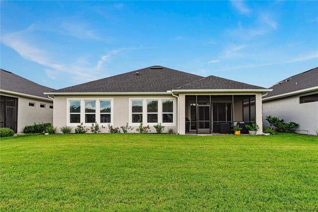 597 Mosaic Blvd, Daytona Beach, FL 32124 - rear view of house featuring a yard, a sunroom, stucco siding, and a shingled roof