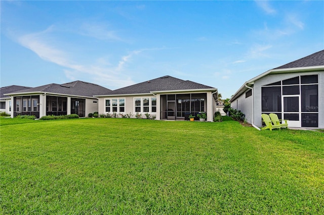 back of property featuring a lawn and a sunroom