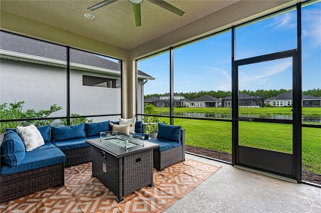 sunroom with a water view, ceiling fan, and a healthy amount of sunlight