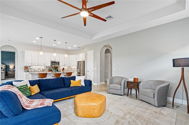 tiled living room with ceiling fan