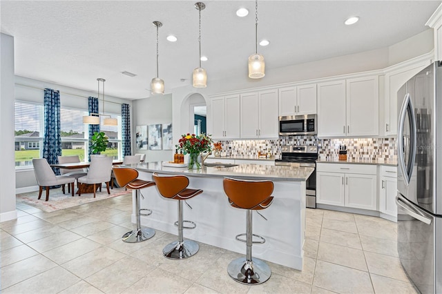 597 Mosaic Blvd, Daytona Beach, FL 32124 - kitchen with stainless steel appliances, a sink, tasteful backsplash, white cabinetry, and light countertops