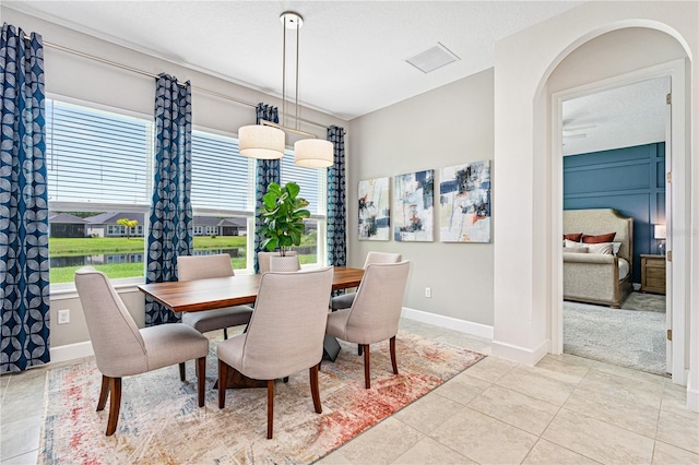 tiled dining space with plenty of natural light and a textured ceiling