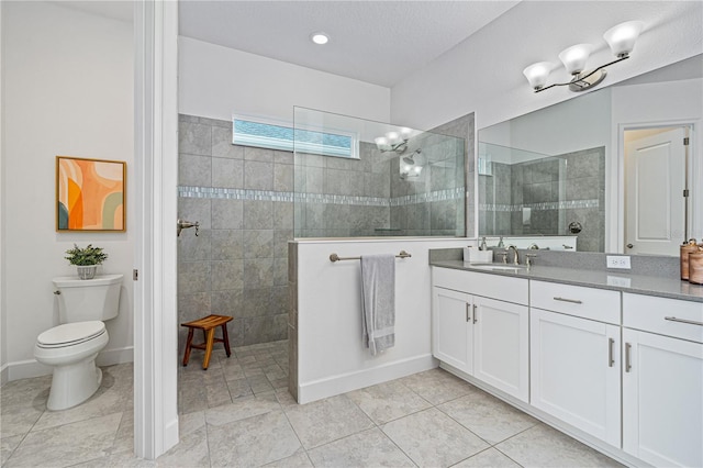 bathroom featuring tiled shower, tile patterned floors, vanity, and toilet