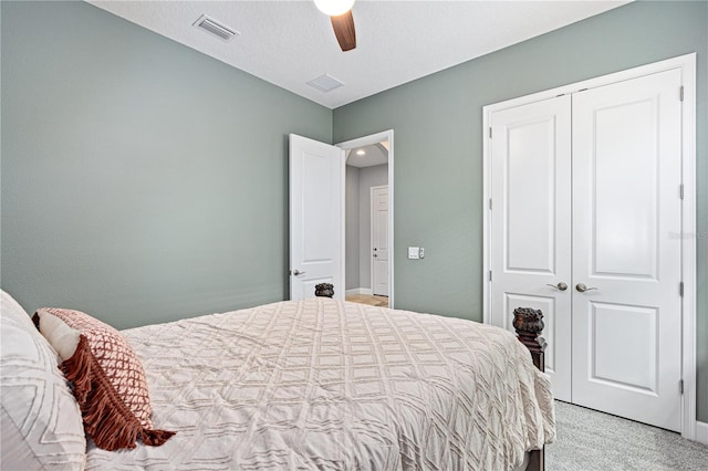 carpeted bedroom with a textured ceiling, a closet, and ceiling fan