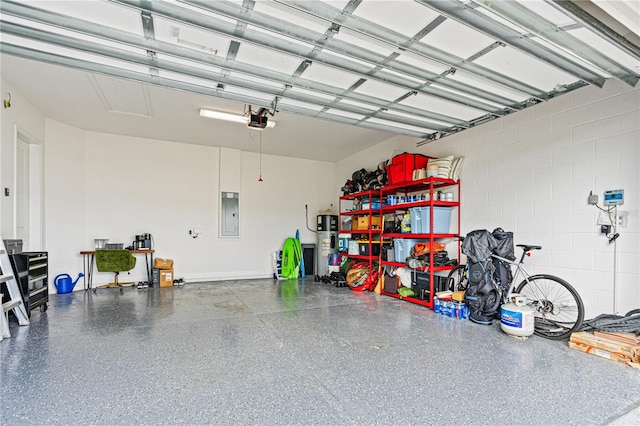 garage with electric panel, a garage door opener, and water heater