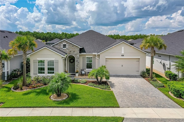 597 Mosaic Blvd, Daytona Beach, FL 32124 - view of front of property featuring stucco siding, an attached garage, decorative driveway, and a front yard