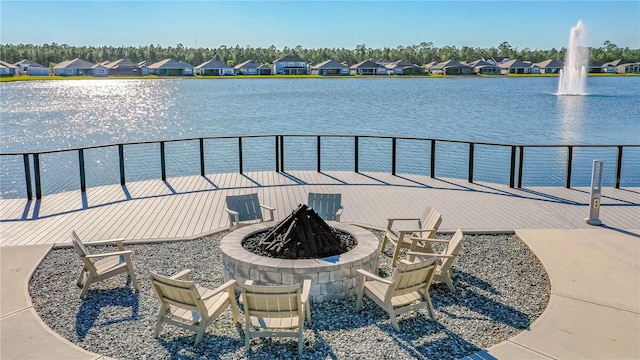 view of patio with a water view and a fire pit