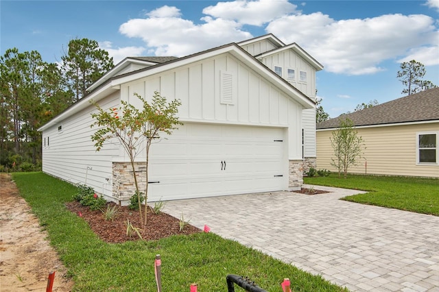 view of side of home featuring a garage and a lawn