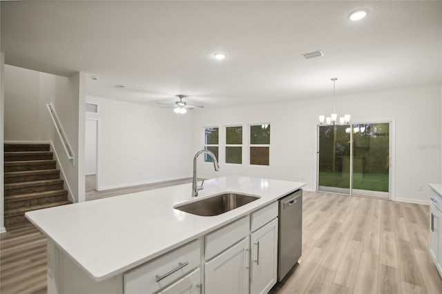 kitchen featuring light wood-type flooring, a kitchen island with sink, sink, pendant lighting, and dishwasher