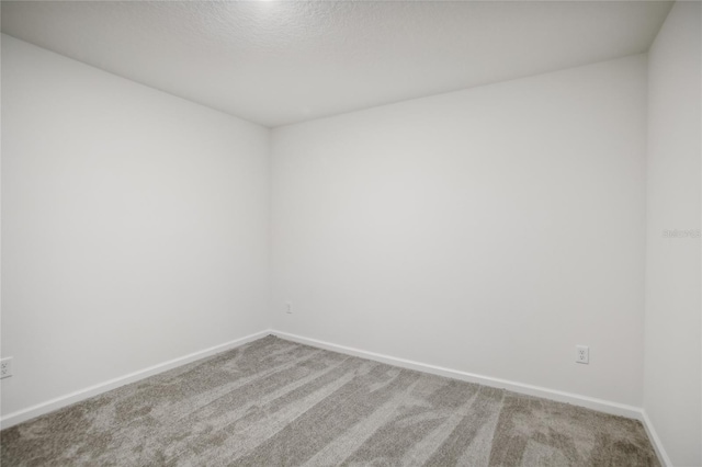 empty room featuring a textured ceiling and carpet floors