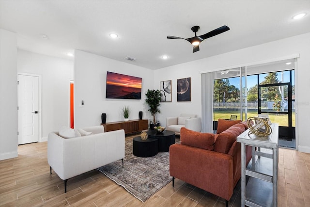 living room with light hardwood / wood-style floors and ceiling fan