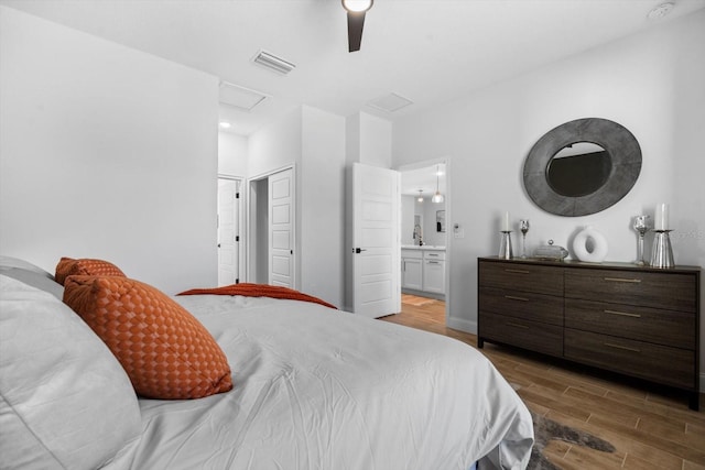 bedroom with ensuite bath, ceiling fan, and dark hardwood / wood-style floors