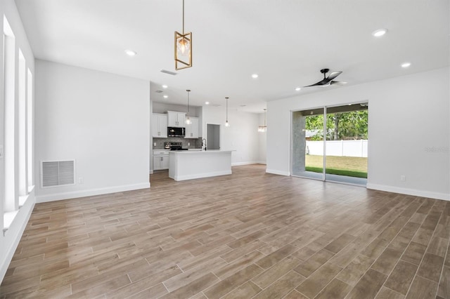 unfurnished living room featuring recessed lighting, visible vents, and light wood-style floors
