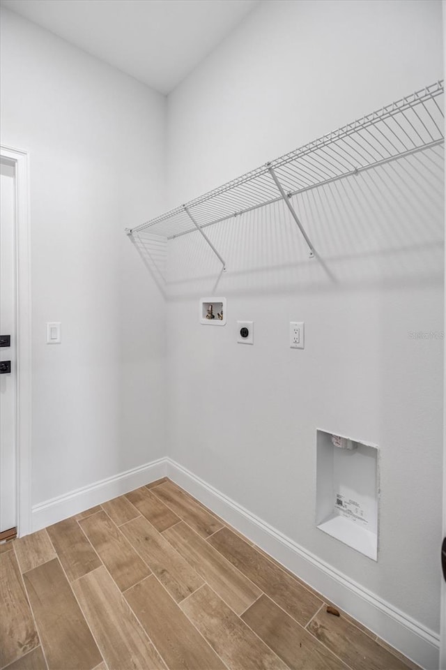 clothes washing area with washer hookup, baseboards, laundry area, wood tiled floor, and electric dryer hookup