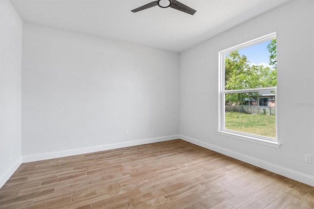 spare room with a ceiling fan, baseboards, and light wood-style floors
