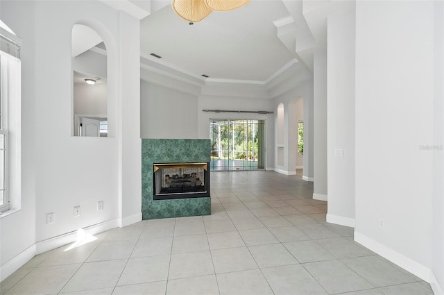 unfurnished living room with ceiling fan, light tile patterned floors, and a fireplace