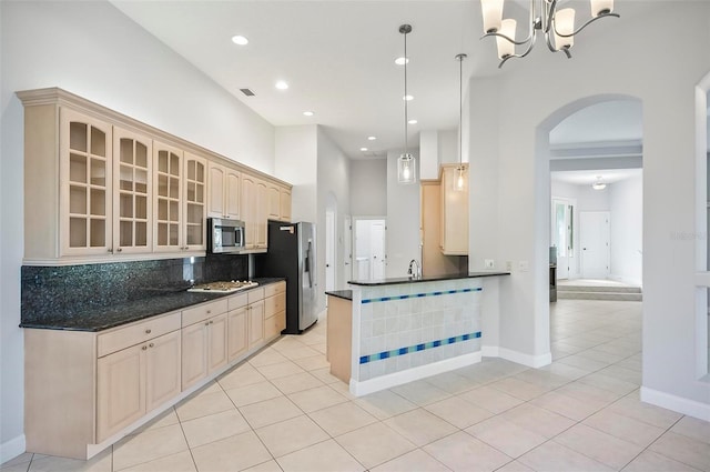 kitchen featuring backsplash, decorative light fixtures, light tile patterned flooring, and stainless steel appliances