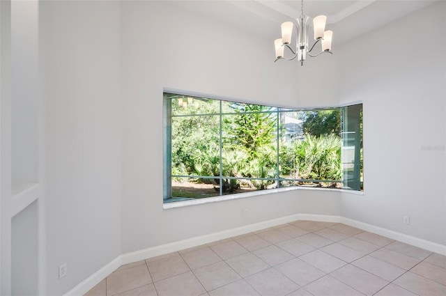 tiled empty room featuring a notable chandelier