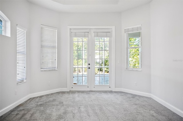 unfurnished room featuring carpet flooring, french doors, and a wealth of natural light