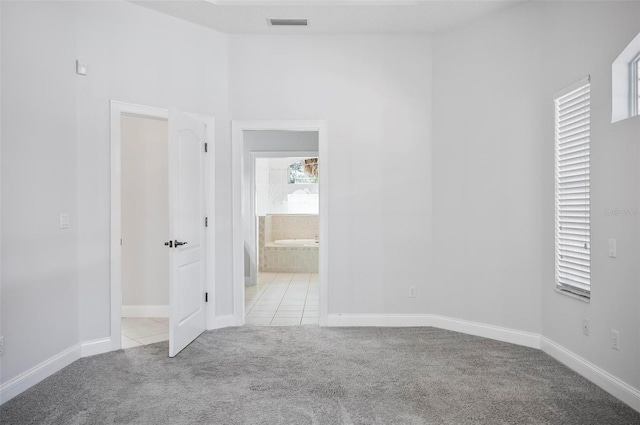 carpeted spare room with a towering ceiling