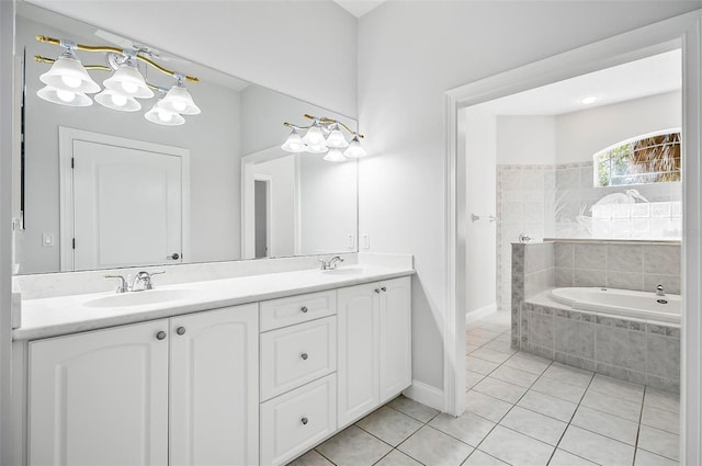 bathroom with tile patterned floors, vanity, and tiled tub