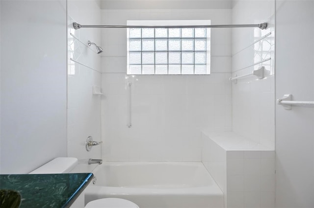 bathroom featuring tiled shower / bath combo and toilet