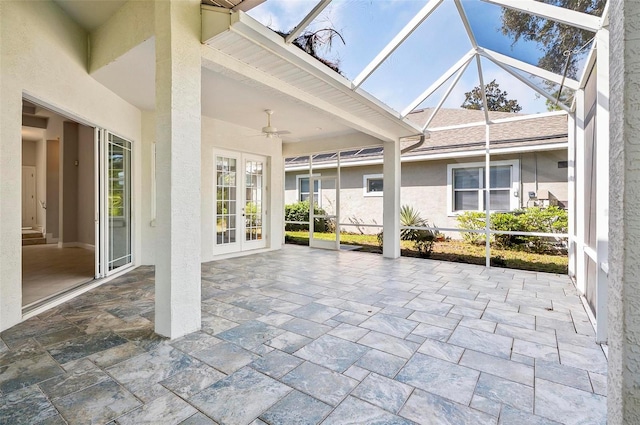 unfurnished sunroom featuring ceiling fan, a skylight, and french doors