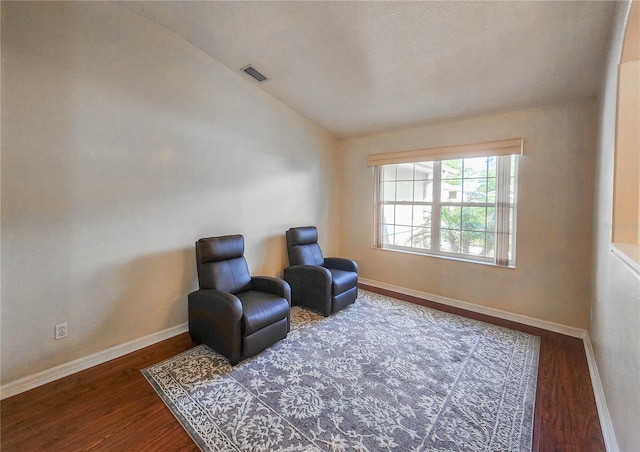 living area with hardwood / wood-style flooring and vaulted ceiling