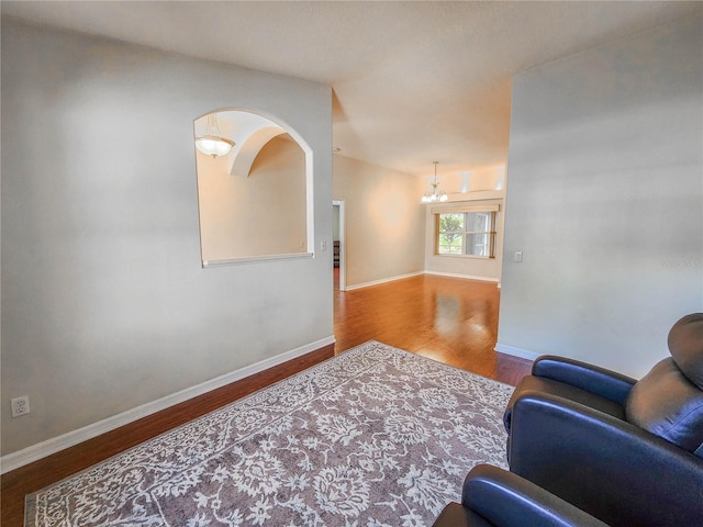 8 Burning Sands Ln, Palm Coast, FL 32137 - living area featuring wood finished floors, a chandelier, baseboards, and arched walkways
