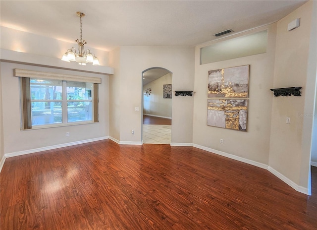 unfurnished room with a notable chandelier and wood-type flooring