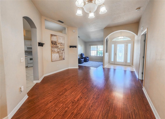8 Burning Sands Ln, Palm Coast, FL 32137 - foyer entrance featuring a chandelier, wood finished floors, arched walkways, and baseboards