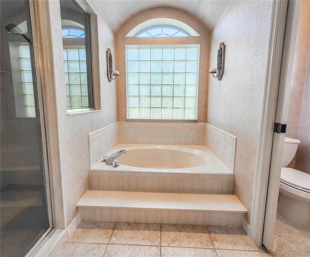 bathroom featuring tile patterned flooring, vaulted ceiling, toilet, and plus walk in shower