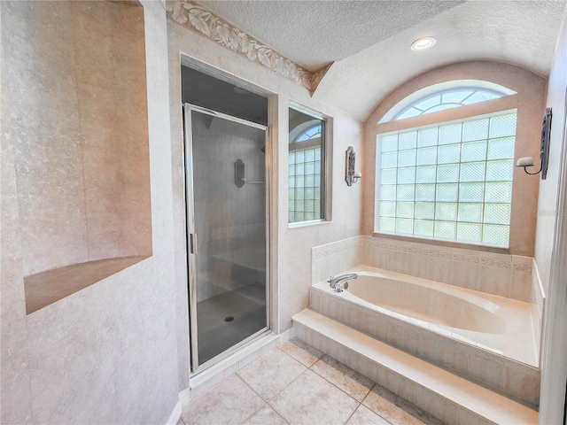 bathroom with plus walk in shower, a textured ceiling, and tile patterned floors